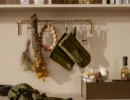 Die Hale Ofenhandschuhe von ferm Living in der Ambienteansicht: Die gemusterten Handschuhe schützen die Finger stilvoll vor heissen Töpfen und Pfannen und können einfach an der Schlaufe aufgehangen werden.