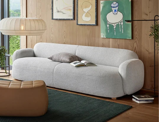 Das Mags Soft Sofa von Hay in der Ambienteansicht: Das hochwertige Ledersofa in Cognac lässt sich perfekt mit beigen Kissen und einem grauen Teppich kombinieren.