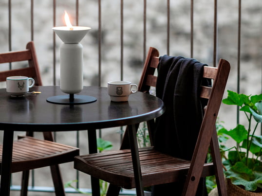 Die Poppy Öllampe von Northern in der Ambienteansicht: Die trichterförmige Öffnung der Lampe erinnert an eine offene Blüte und setzt damit elegante Akzente auf dem Balkon oder der Terrasse.
