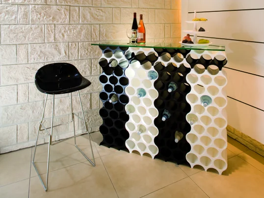 Im Gegensatz zu Spirituosen sollte Wein liegend in einem Weinflaschenregal gelagert werden. Durch das Liegen wird der Korken feucht gehalten und der Wein kann nicht oxidieren.