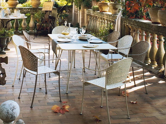 Der Rendez-Vous Tisch und Stuhl von Fermob wirkt im Garten gemütlich und romantisch. Dank des pflegeleichten Materials und der Aussparungen ist es besonders wetterbeständig und langlebig.