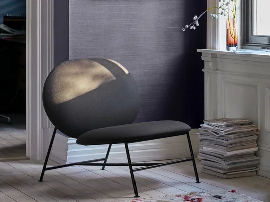 Der Northern - Oblong Lounge Chair in der Ambienteansicht. Minimalistisch gestaltet mit einem schmalen Untergestell aus Stahl und zwei grosszügigen, ovalen Kaltschaum-Polstern für die Sitzfläche sowie die Rückenlehne, fügt sich der niedrige Lounge Sessel bestens in jede Einrichtung ein, ohne dabei aufdringlich zu wirken. 