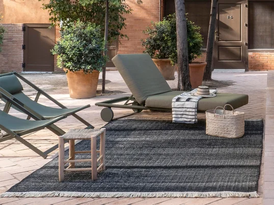 Der Tres Outdoor-Teppich von nanimarquina sorgt selbst im Pool-Bereich für eine unheimlich gemütliche Atmosphäre und gibt dem Aussenbereich ein wohnliches Ambiente.