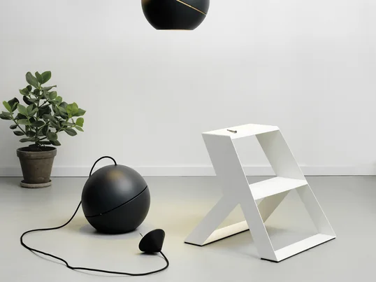 Die Split Step Trittleiter von Frederik Roijé in weiss in der Ambienteansicht. Die Trittleiter eignet sich bestens dazu Pendelleuchten an der Decke zu montieren.