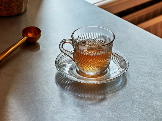 Die klassische Pirouette Tasse mit der passenden Untertasse von Hay überzeugt durch das transparente Material und das umlaufende wirbelnde Rippenmuster.