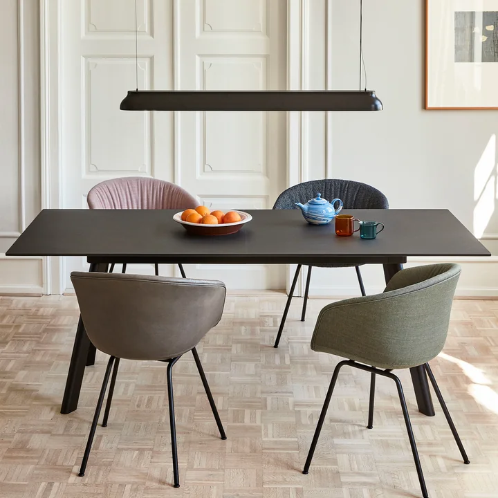 Die PC Linear Stab-Pendelleuchte, soft black von HAY über einem schwarzem, rechteckigen Esstisch