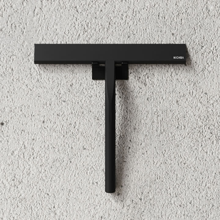 Der Duschabzieher von Nichba Design an einer Steinwand