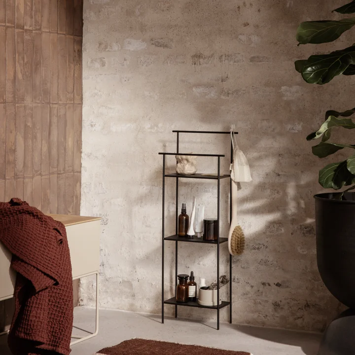 Das Dora Badezimmerregal von Ferm Living mit Bad-Accessoires neben einer grossen Zimmerpflanze