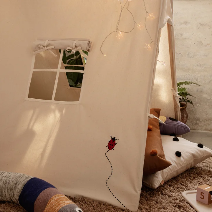 Das Spielzelt von Ferm Living mit Kissen und Lichterketten im Kinderzimmer