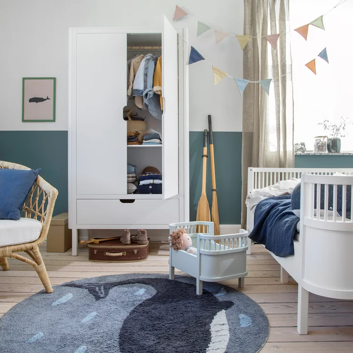 Der geöffnete Kinder-Kleiderschrank 2-türig von Sebra im Kinderzimmer mit blauen Akzenten