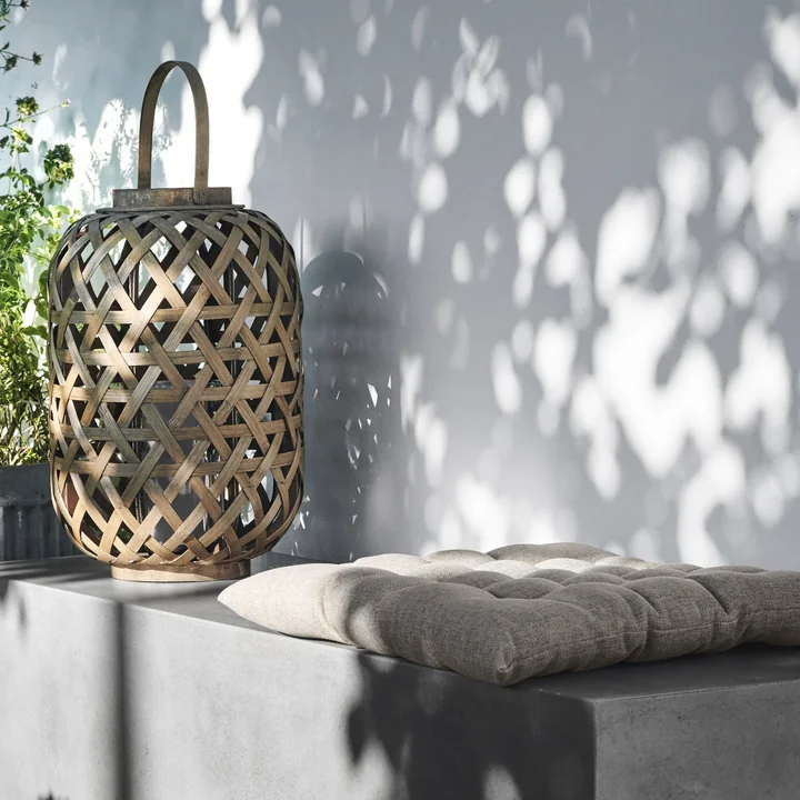 Das Fine Outdoorkissen von House Doctor auf einer Beton-Bank