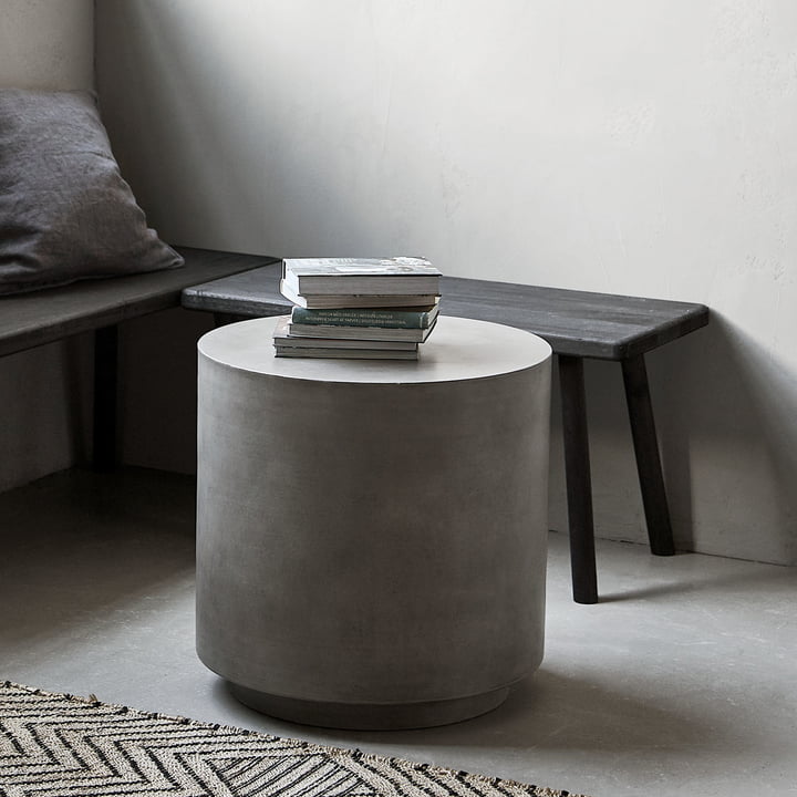 Der Out Beton Beistelltisch von House Doctor vor einer Bank im Wohnzimmer