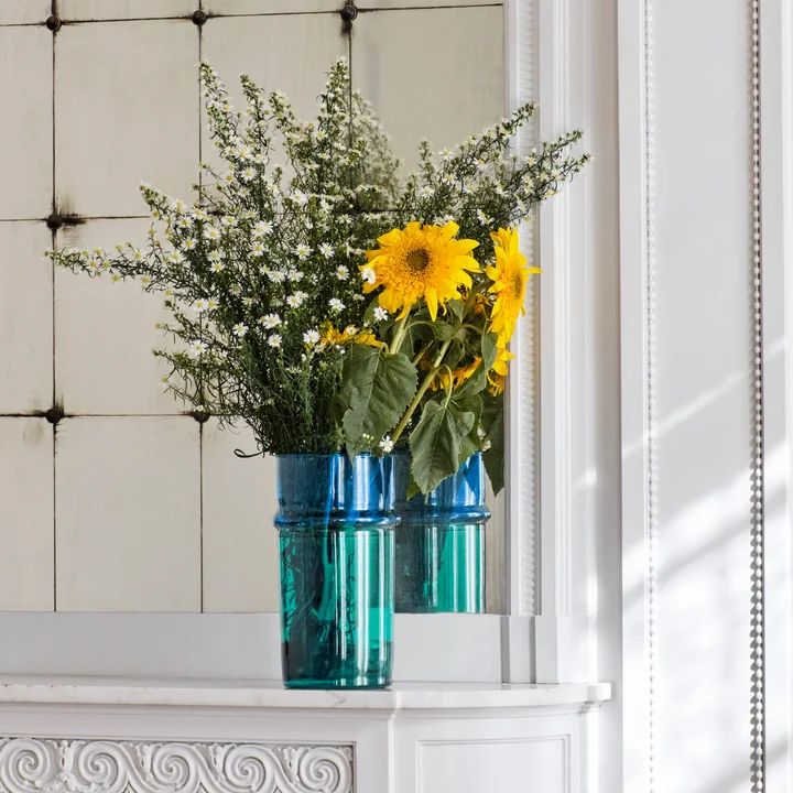 Die blau-grüne Marokkanische Vase von HAY mit gelben Blumen