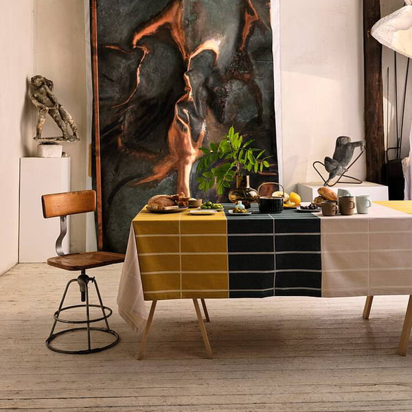 Die Tiiliskivi Tischdecke von Marimekko auf einem Esstisch in einem kunstvoll eingerichteten Zimmer